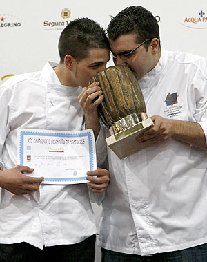 El campeón Juan Rodríguez Morilla y su ayudante besando el premio/Efe